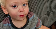 Sawyer is registered to the contest to win money with this photo: toddler, child, portrait, sitting, couch, indoors, blond_hair, blue_eyes, face, serious_expression, striped_shirt, shorts, arm, hand, furniture, upholstery, close_up, candid, home, photography