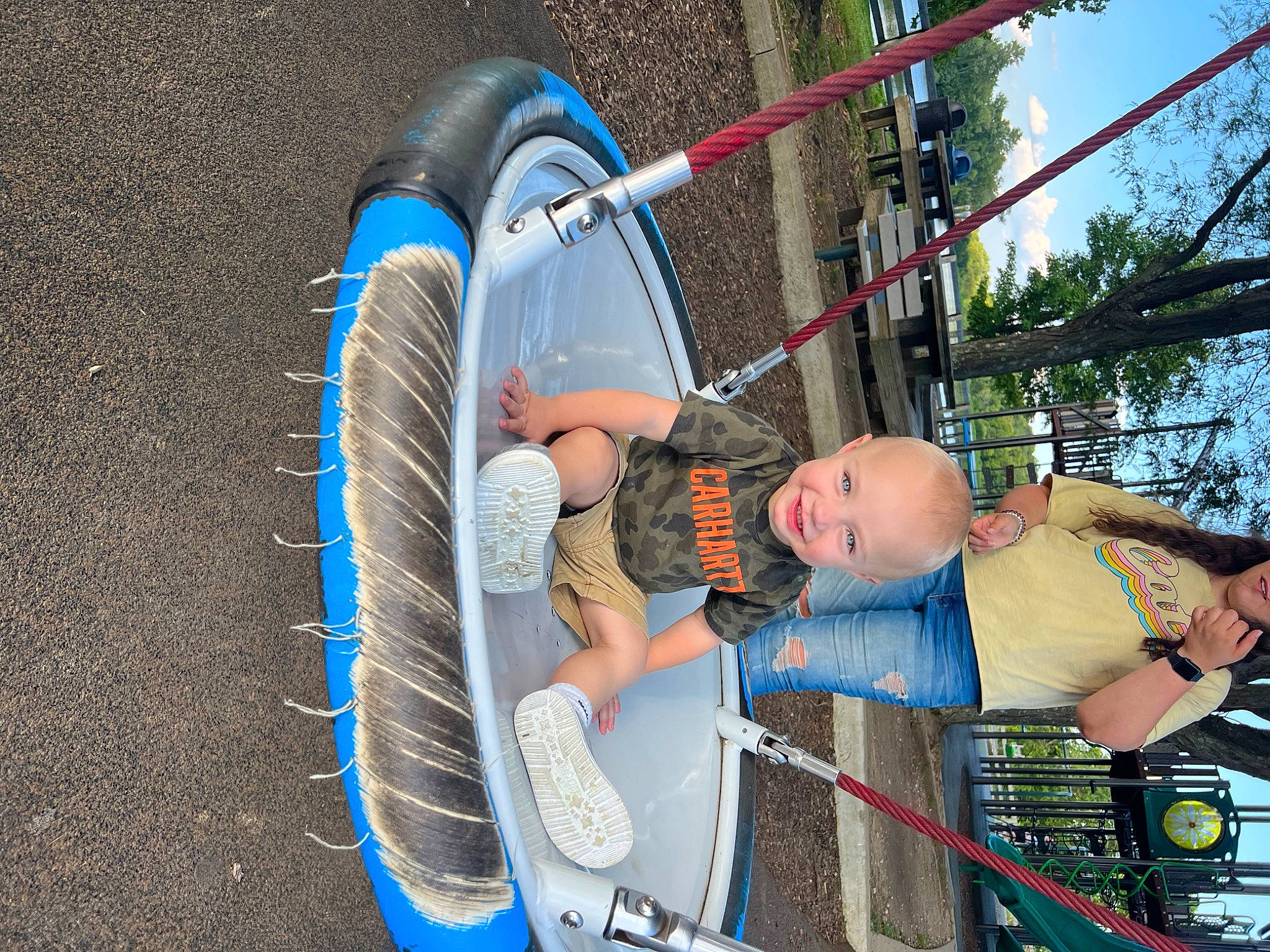 Grayson is registered to the contest to win money with this photo: auto_part, automotive_tire, bicycle_tire, boats_and_boating_equipment_and_supplies, child, electric_blue, fun, hammock, hat, joy, leisure, outdoor_play_equipment, outdoor_recreation, person, recreation, rope, sky, sneakers, tire, toddler