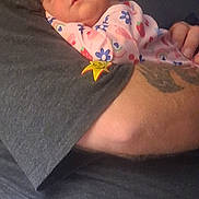 Abigail is registered to the contest to win money with this photo: baby, sleeping, infant, onesie, floral_pattern, arm, tattoo, hand, person, closeup, skin, pink, blue, red, adult, comfort, rest, tenderness, love, cozy