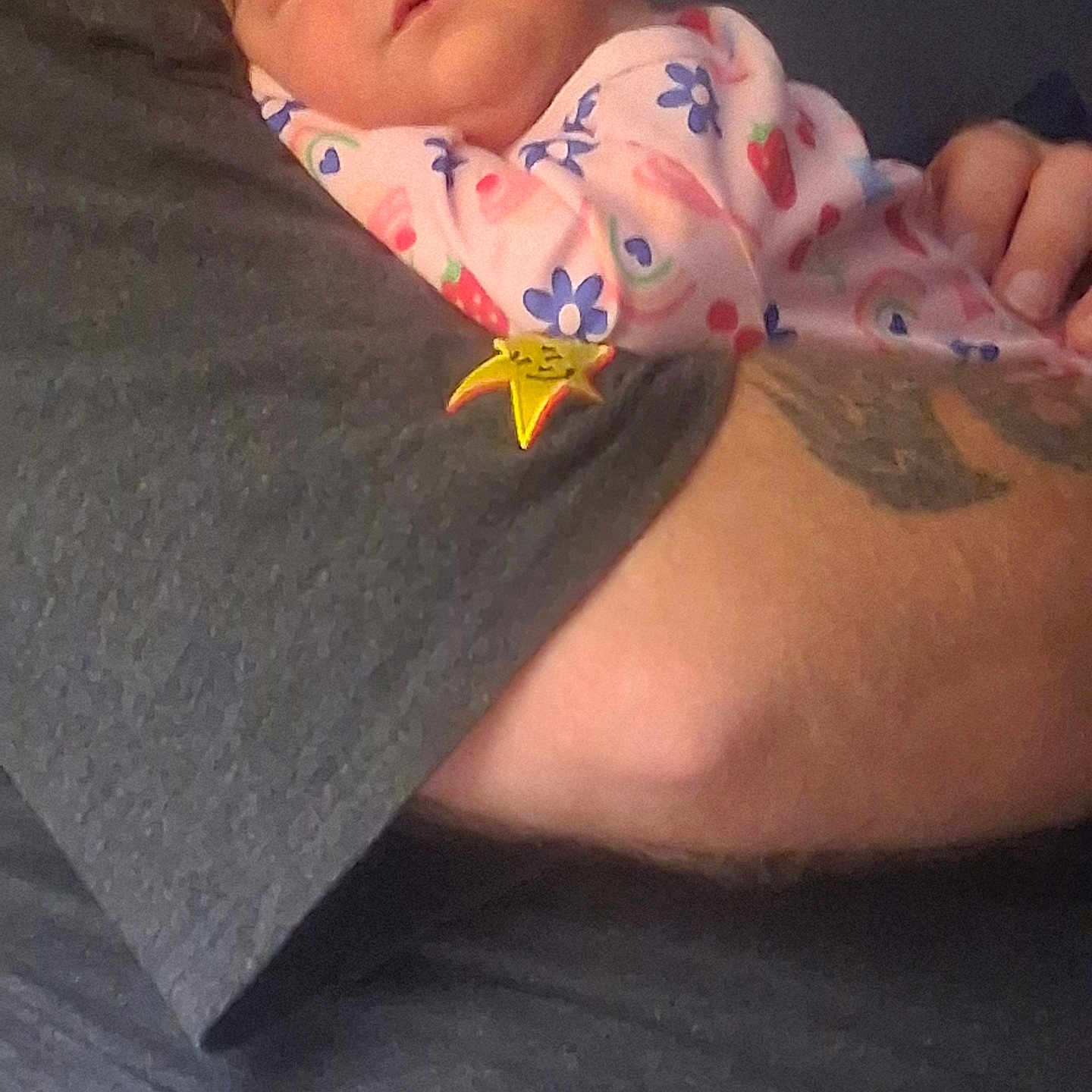 Abigail is registered to the contest to win money with this photo: baby, sleeping, infant, onesie, floral_pattern, arm, tattoo, hand, person, closeup, skin, pink, blue, red, adult, comfort, rest, tenderness, love, cozy