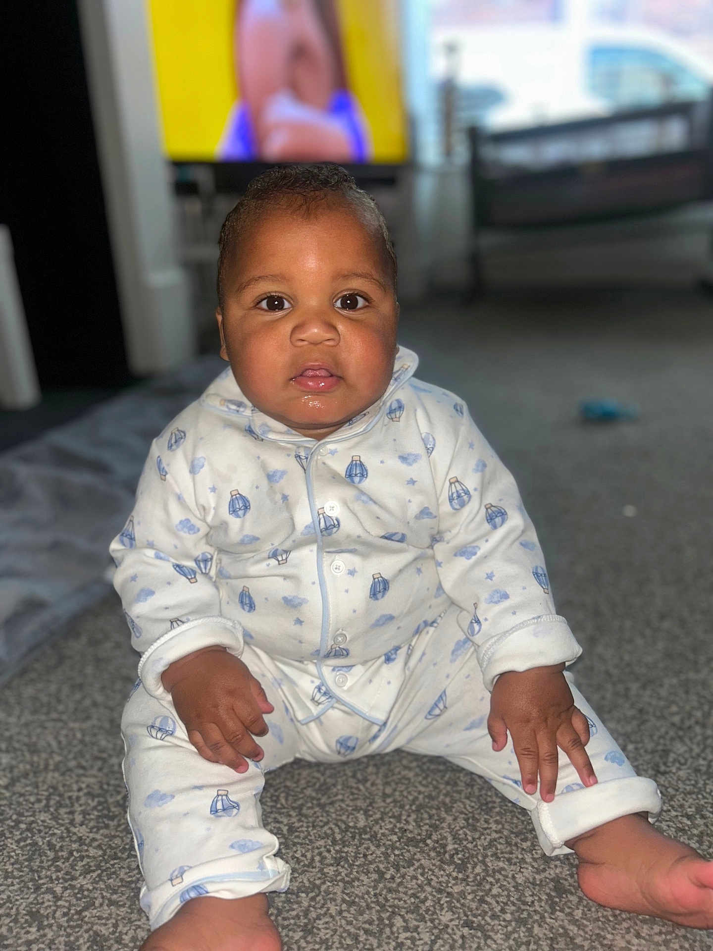 Raphael joined the competition — help win amazing prizes! baby, child, pajamas, carpet, floor, drool, indoor, face, person, sitting, clothing, cute, home, infant, looking, young_child, portrait, hands, feet, television