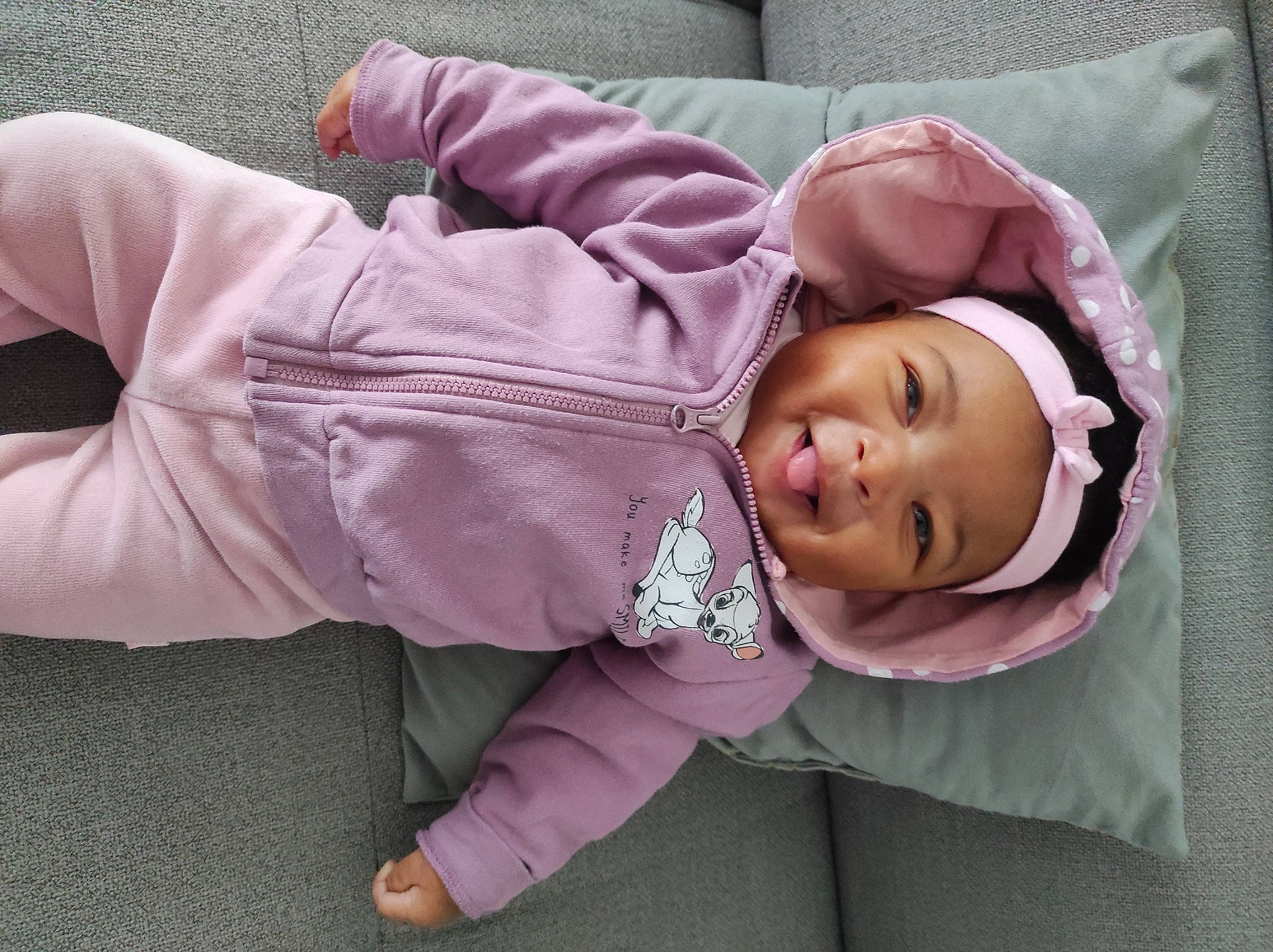 Tiana a rejoint le concours — aidez-le/la à gagner de superbes lots ! baby, baby_products, baby_toddler_clothing, cheek, child, comfort, eye, facial_expression, grass, headwear, lip, magenta, outerwear, person, pink, purple, skin, sleeve, textile, toddler