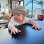 Milo-Chrisopher is registered to the contest to win money with this photo: baby, hat, table, outdoor, cafe, child, face, hands, sunlight, sea, sky, plant, chair, person, window, building, daylight, portrait, curious, casual