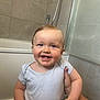 baby, child, smile, tooth, arm, hand, bathroom, bathtub, tile, wall, person, white_clothing, happy, cute, infant, holding, head, face, skin, young