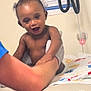 Jaylen joined the competition — help win amazing prizes! baby, child, smiling, happy, curly_hair, diaper, arm, adult_hand, medical_equipment, clinic, examination_table, notice, person, indoor, healthcare, skin, expression, holding, playful, cute