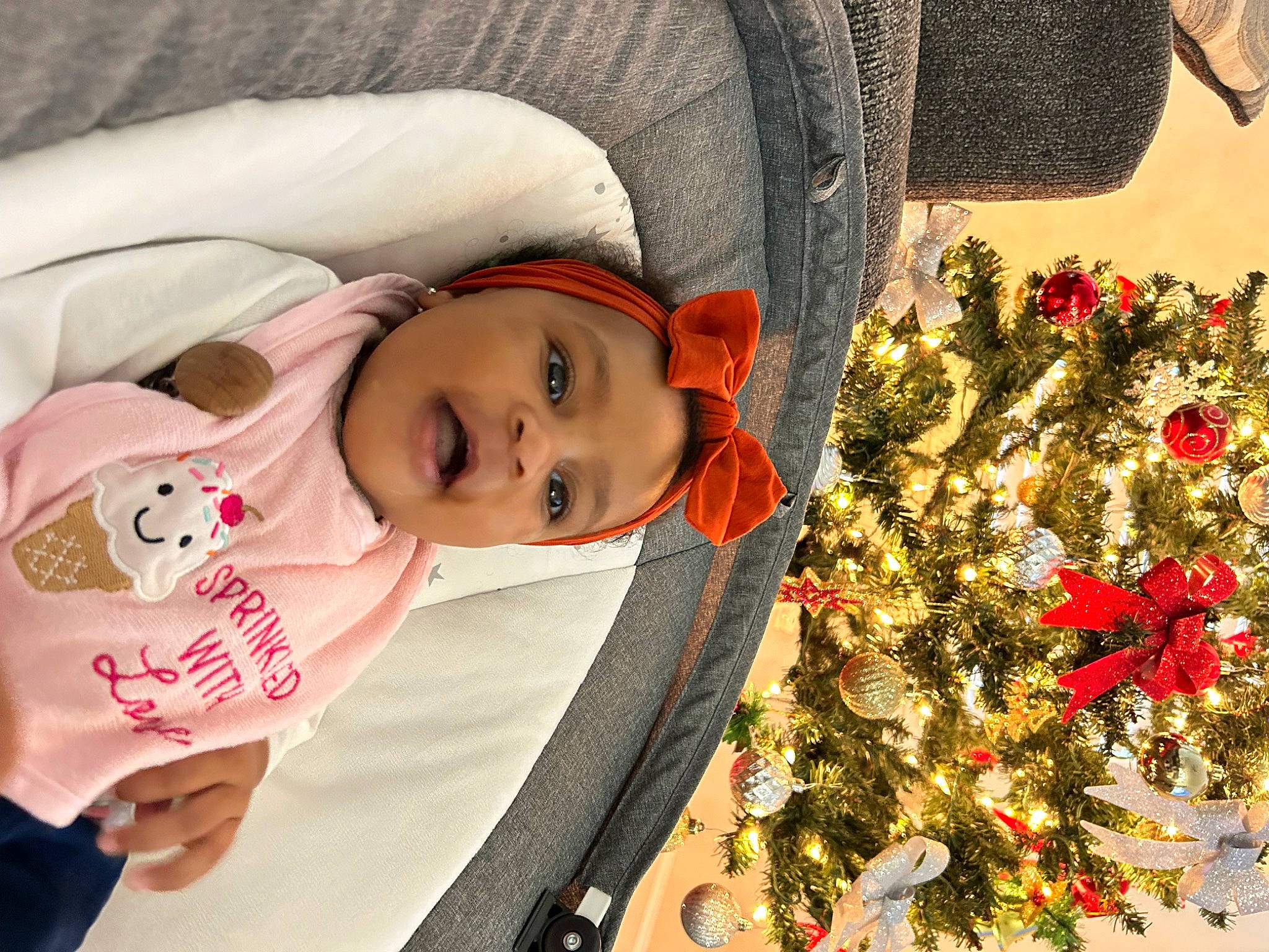 Aubrie is registered to the contest to win money with this photo: beauty, child, christmas_decoration, christmas_ornament, christmas_tree, event, eye, facial_expression, flower, happy, head, headwear, holiday, leaf, outerwear, person, plant, smile, textile, toddler