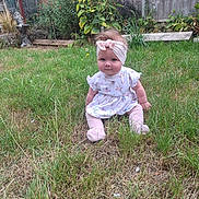 Austeja joined the competition — help win amazing prizes! baby, child, girl, headband, dress, grass, garden, outdoor, greenery, fence, plant, flower, sitting, cute, young, portrait, nature, summer, smile, head