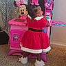 Giovanna joined the competition — help win amazing prizes! back_view, carpet, child, child_playing, curtains, cute, footwear, furniture, hair_buns, holiday_outfit, home, indoor, minnie_mouse, person, pink, play, red_dress, toddler, toy_kitchen, white_fur_trim
