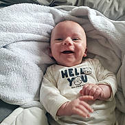 Mylann a rejoint le concours — aidez-le/la à gagner de superbes lots ! baby, smiling, blanket, clothing, infant, cute, happy, portrait, face, child, cozy, sitting, soft, indoors, toddler, apparel, newborn, expression, warm, person