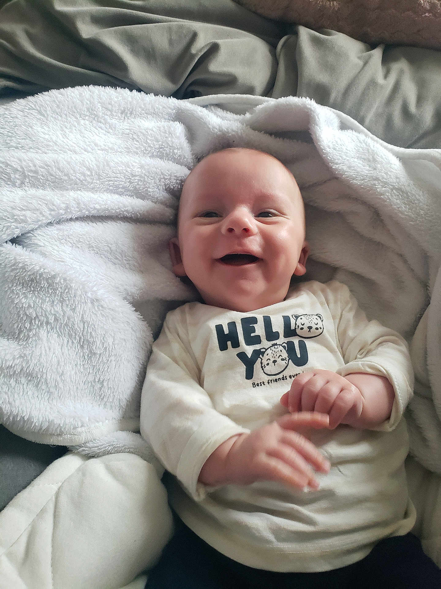 Mylann a rejoint le concours — aidez-le/la à gagner de superbes lots ! baby, smiling, blanket, clothing, infant, cute, happy, portrait, face, child, cozy, sitting, soft, indoors, toddler, apparel, newborn, expression, warm, person