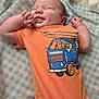 Paxton is registered to the contest to win money with this photo: baby, blanket, blue_van, cartoon, child, clothing, crocodile, cute, happy, indoors, infant, laughing, lying_down, newborn, orange_onesie, person, playful, smile, soft, tongue_out