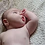 baby, infant, skin, blanket, texture, soft, lying_down, curious, expression, face, arm, hand, indoors, closeup, child, newborn, resting, peaceful, portrait, natural_light