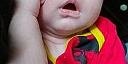Paxton is registered to the contest to win money with this photo: baby, infant, child, face, hand, red_clothing, yellow_clothing, sleepy, tired, skin, arm, portrait, closeup, indoors, person, cute, resting, expression, young, casual