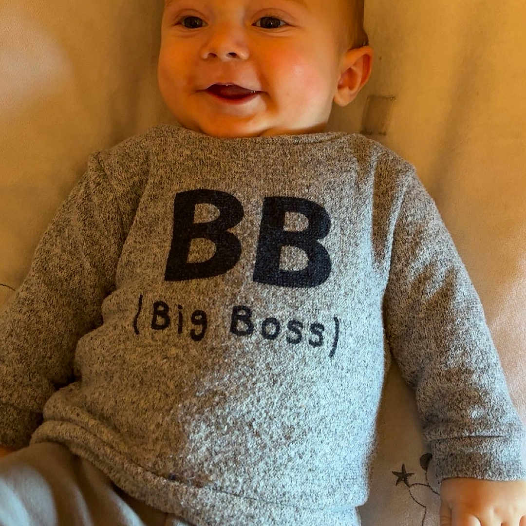 Soan participe au concours pour gagner de l'argent avec cette photo : baby, bed, blanket, child, cozy, cute, face, grey_clothing, hand, happy, indoor, infant, lying_down, person, pillow, portrait, smiling, soft_lighting, sweater, text_on_clothing