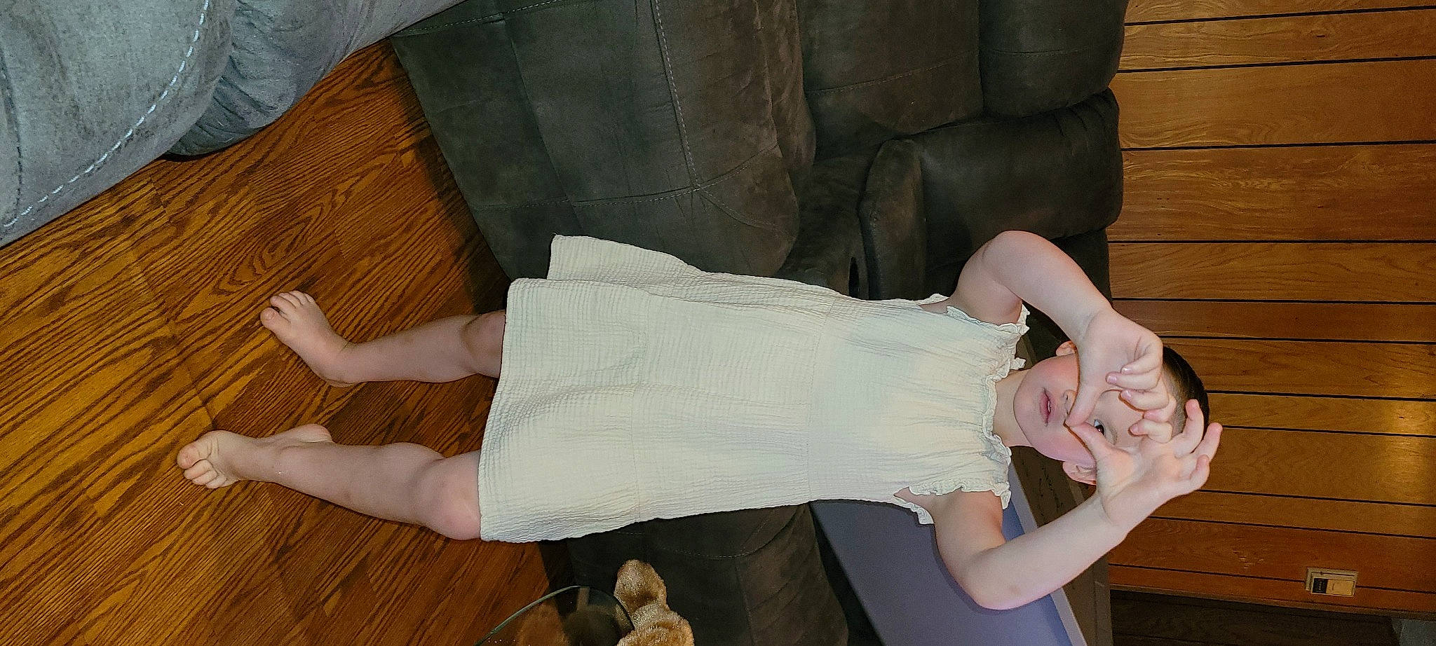 Delilah is registered to the contest to win money with this photo: arm, comfort, couch, dress, flooring, foot, hardwood, headwear, human_leg, joint, knee, leg, person, room, textile, thigh, trunk, varnish, waist, wood