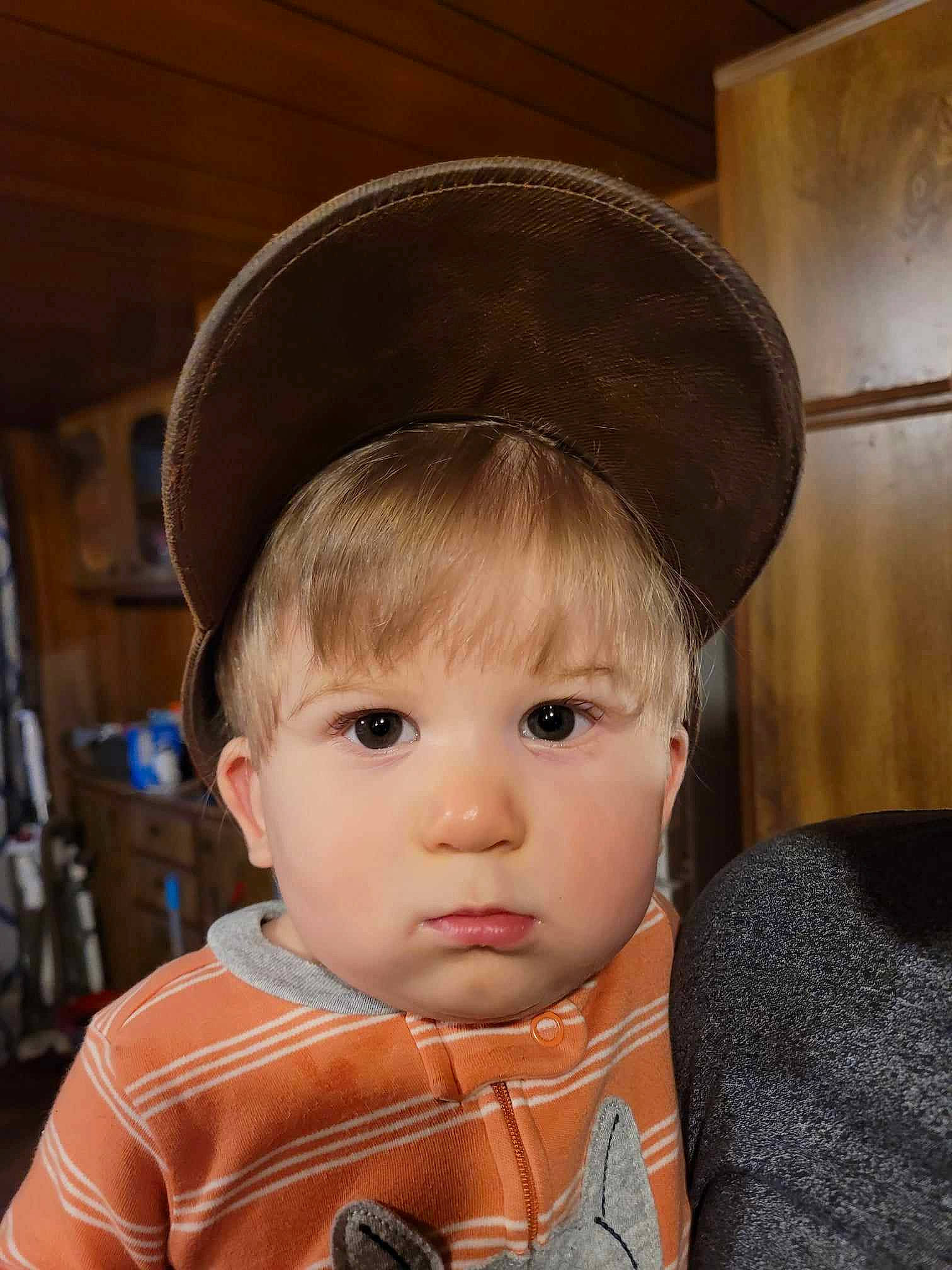 Levi is registered to the contest to win money with this photo: baby, baby_toddler_clothing, bangs, cap, cheek, chin, clothing, costume_hat, eye, eyebrow, eyelash, fedora, hat, head, iris, lip, nose, outerwear, person, sleeve