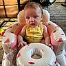 baby, infant, child, yellow_onesie, inflatable_seat, pink, white, candy_print, bunny_print, face, expression, home_interior, carpet, chair, toy, floor, person, sitting, cute, indoor