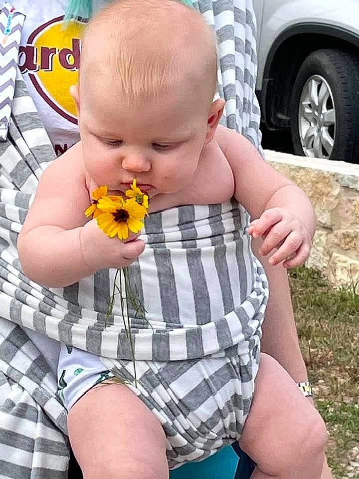Zane is registered to the contest to win money with this photo: automotive_tire, baby_toddler_clothing, child, finger, fun, grass, hand, head, joint, orange, pattern, person, plaid, sleeve, summer, tartan, thumb, tire, toddler, wheel