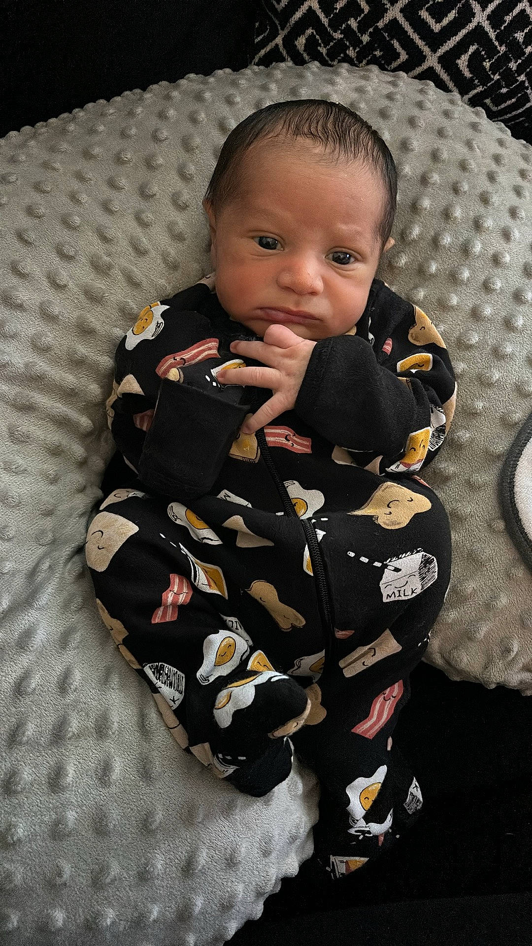 Kamari is registered to the contest to win money with this photo: baby, baby_products, baby_toddler_clothing, cheek, child, comfort, eye, face, flooring, formal_wear, gesture, hair, head, military_camouflage, pattern, person, sitting, sleeve, suit, thumb