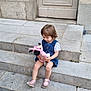 Angelina a rejoint le concours — aidez-le/la à gagner de superbes lots ! toddler, child, plush_toy, steps, stone, outdoor, dress, sandals, toy, curly_hair, building, door, concrete, cute, sitting, young_child, playful, daylight, casual_clothing, person