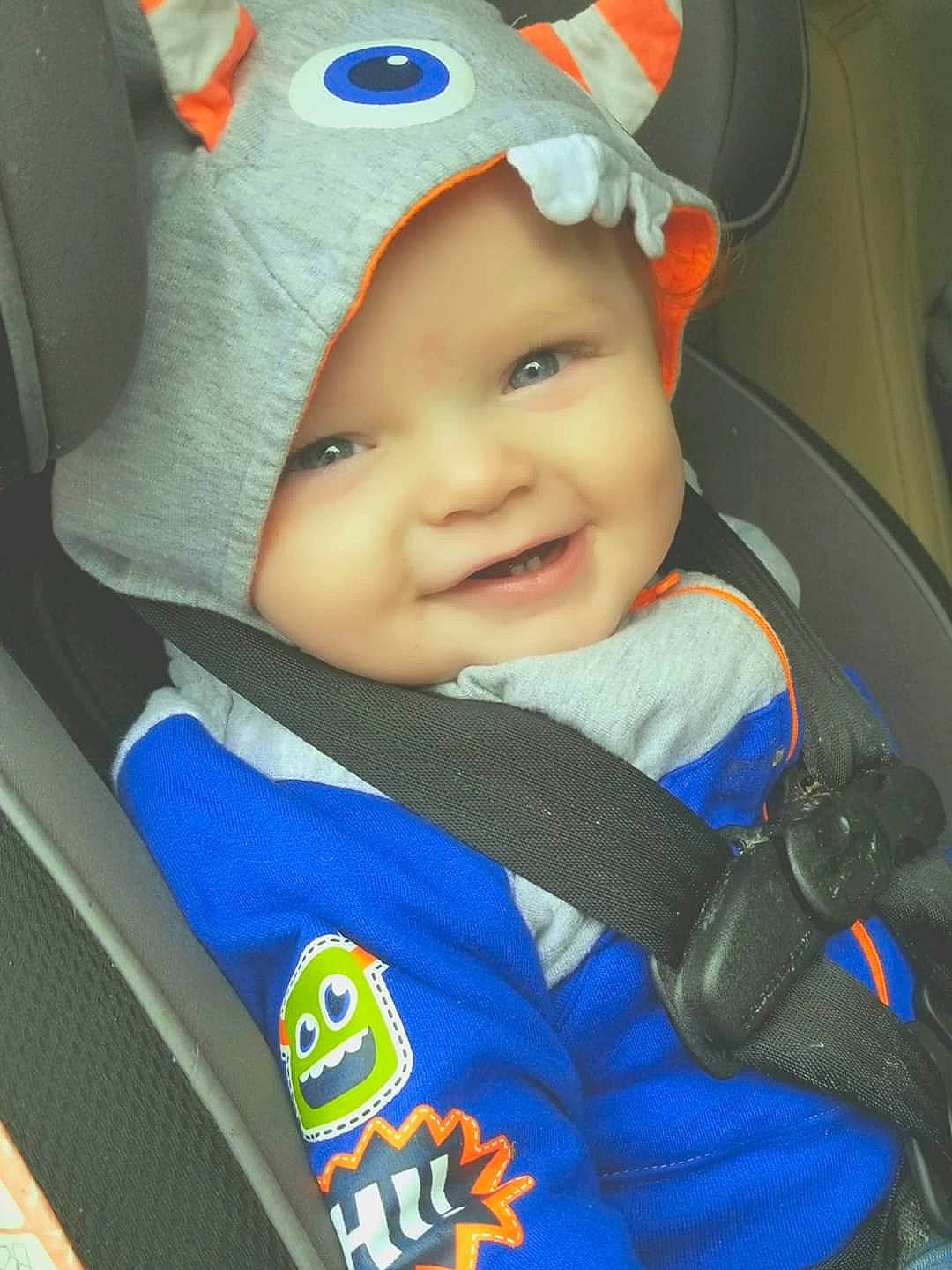 Bryson is registered to the contest to win money with this photo: auto_part, azure, baby, baby_carriage, baby_in_car_seat, baby_products, blue, cap, car_seat, child, electric_blue, face, happy, head, headwear, joy, person, personal_protective_equipment, product, seat_belt