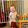 Elliot joined the competition — help win amazing prizes! toddler, child, baby_gate, toy, stuffed_toy, carpet, ball, smiling, indoor, person, playroom, furniture, wooden_door, clothing, foot, head, face, happy, colorful, plastic