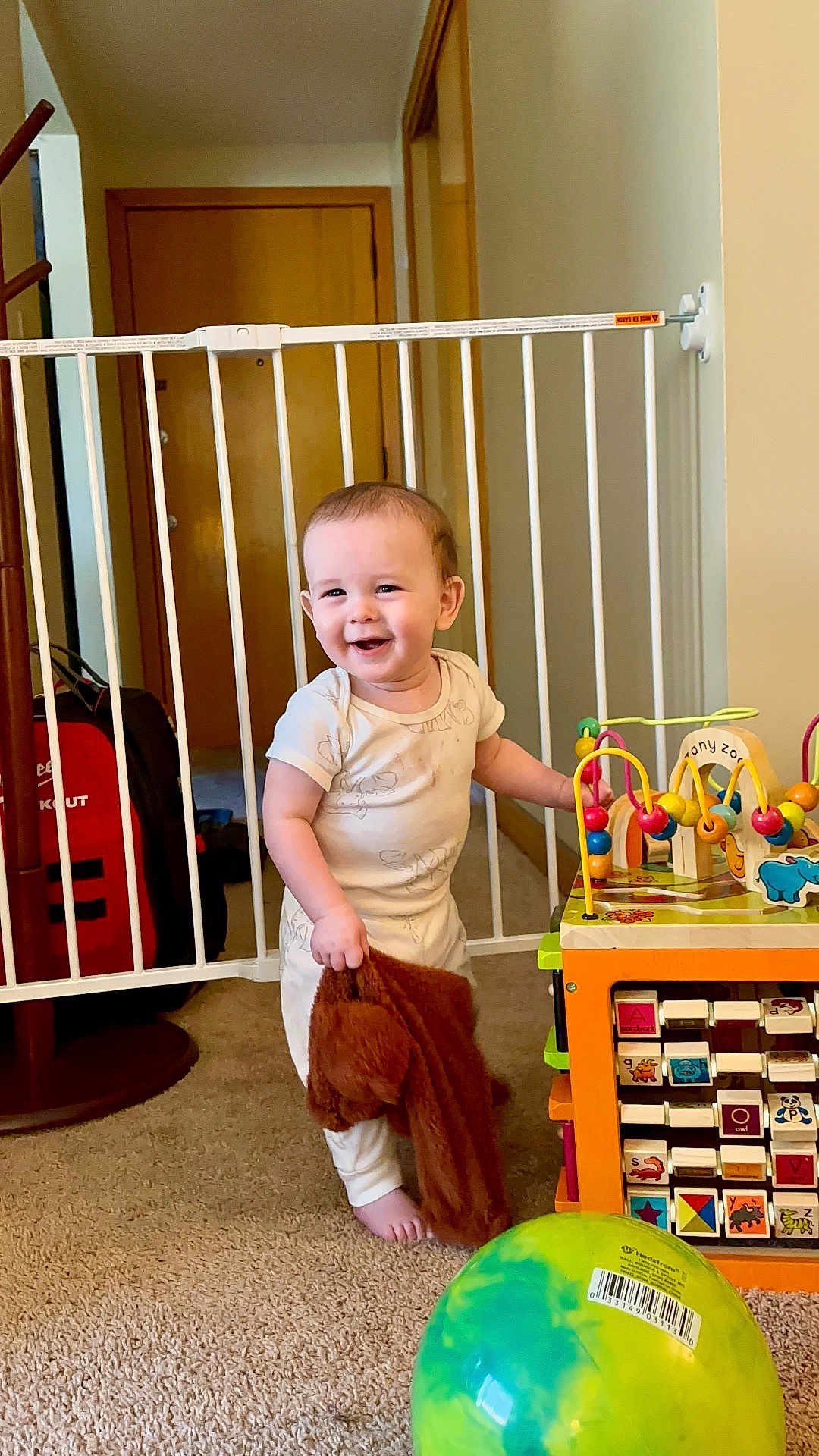 Elliot joined the competition — help win amazing prizes! toddler, child, baby_gate, toy, stuffed_toy, carpet, ball, smiling, indoor, person, playroom, furniture, wooden_door, clothing, foot, head, face, happy, colorful, plastic