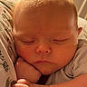 Atticus is registered to the contest to win money with this photo: newborn, baby, infant, sleeping, face, closed_eyes, puckered_lips, frown, portrait, close_up, soft_lighting, warm_tones, blanket, swaddle, knit_clothing, cozy, indoors, resting, peaceful, adorable