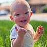baby, smiling, grass, outdoor, child, hands, happy, sunlight, face, head, nature, daylight, greenery, cute, portrait, young_child, casual_clothing, sitting, skin, expression