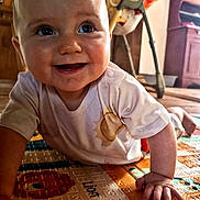 Leiré a rejoint le concours — aidez-le/la à gagner de superbes lots ! baby, crawling, smiling, indoor, play_mat, alphabet, child, clothing, hand, face, person, furniture, wooden, toy, bright, happy, cute, floor, expression, infant