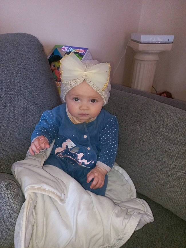 Alessia a rejoint le concours — aidez-le/la à gagner de superbes lots ! baby, baby_toddler_clothing, beanie, cap, child, comfort, costume_hat, couch, fashion_accessory, fun, hat, headgear, headwear, lap, living_room, pattern, person, room, sitting, sleeve
