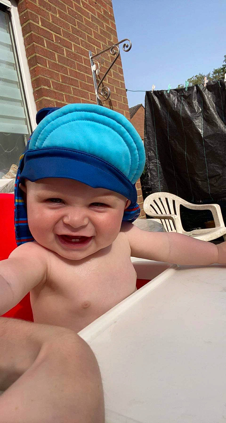 Thiago participe au concours pour gagner de l'argent avec cette photo : baby, baseball_cap, cap, chest, event, fashion_accessory, fun, happy, hat, headgear, headwear, leisure, mobile_phone, person, personal_protective_equipment, recreation, sand, sky, smile, summer