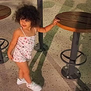 Eva a rejoint le concours — aidez-le/la à gagner de superbes lots ! casual_clothing, child, concrete_floor, curly_hair, cute, footwear, holding, legs, nighttime, outdoor, person, playground, recreation, shadow, small_person, smiling, standing, white_shoes, wooden_stool, young_child