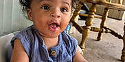Jasper is registered to the contest to win money with this photo: baby, blue_clothing, buttoned_shirt, child, curly_hair, cute, expression, face, floor, hand, high_chair, home, indoor, mouth_open, person, reflection, seat, smiling, window, wooden_chair