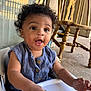 baby, child, high_chair, curly_hair, blue_clothing, wooden_chair, indoor, mouth_open, expression, face, person, seat, hand, window, reflection, home, floor, buttoned_shirt, smiling, cute