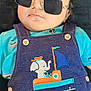 baby, child, sunglasses, denim, overall, elephant, boat, patch, clothing, cute, portrait, face, infant, blue, orange, buttons, lying_down, indoor, serious, fashion