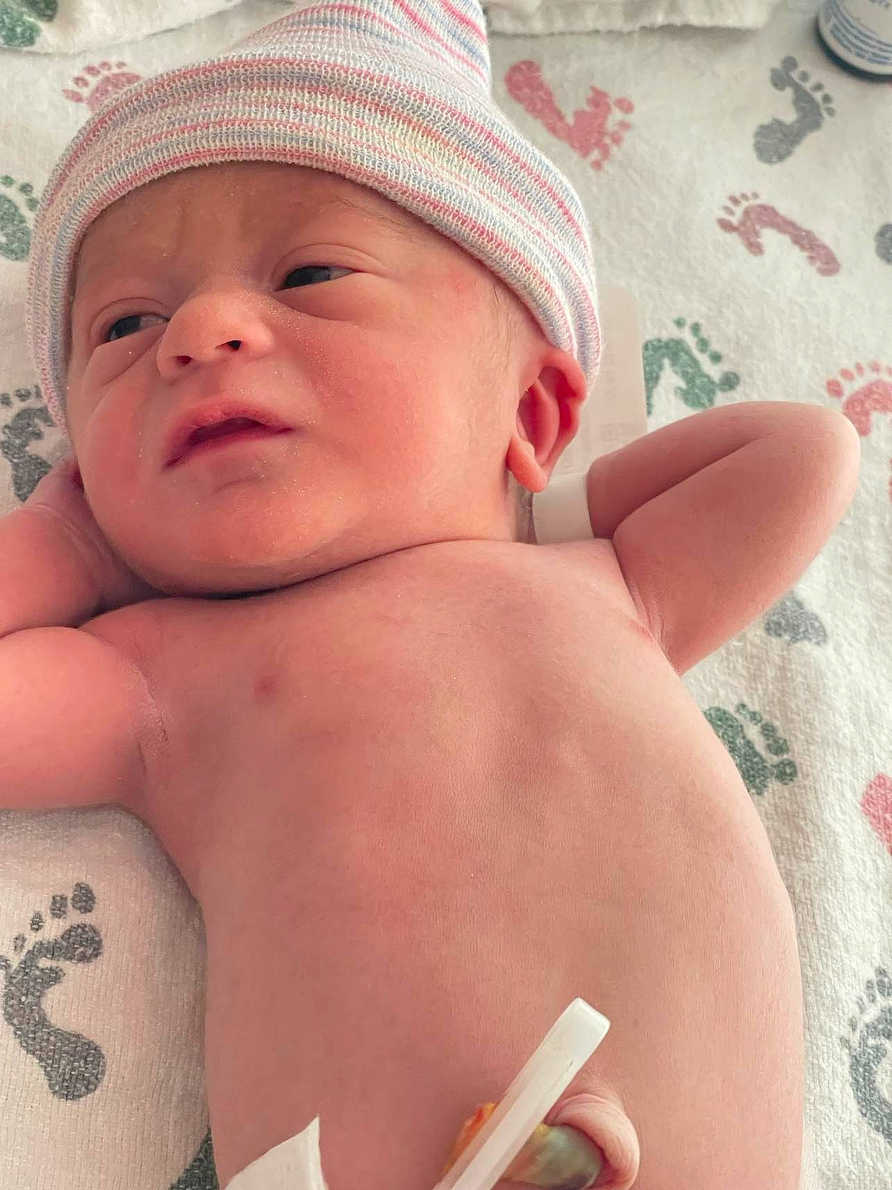 Jeremy is registered to the contest to win money with this photo: arm, baby, cap, cheek, chin, eye, eyebrow, face, facial_expression, hand, hat, head, headwear, human_body, lip, mouth, muscle, nose, organ, person