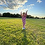 Esme-Ella is registered to the contest to win money with this photo: baby, clothing, face, field, footwear, grass, green, happy, head, nature, outdoors, park, person, photography, plant, portrait, shoe, sky, standing, triumphant