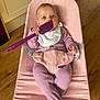 Mabel is registered to the contest to win money with this photo: baby, child, infant, blue_eyes, pink_chair, purple_spatula, bib, onesie, footed_pajamas, wooden_floor, indoor, kitchen, curious, cute, sitting, holding_object, face, person, home, furniture