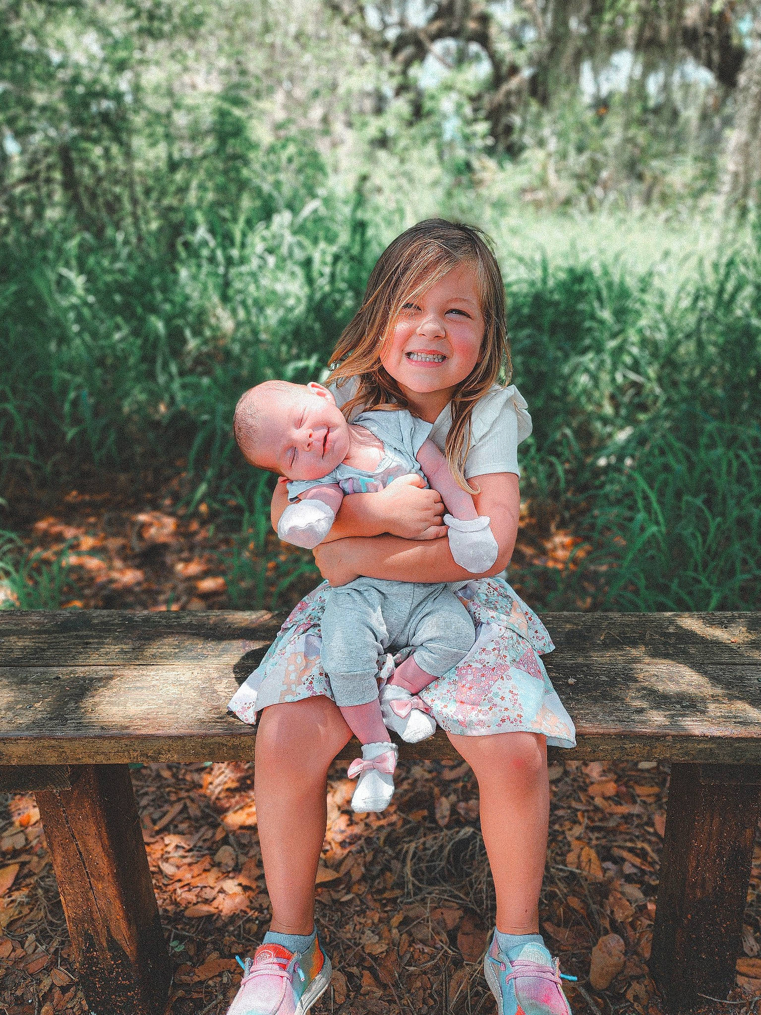 Sophia is registered to the contest to win money with this photo: baby, blond, child, flash_photography, forest, fun, grass, happy, human_leg, joy, leisure, morning, nature, people, people_in_nature, person, plant, sandal, sitting, summer