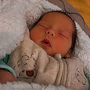 Elyo a rejoint le concours — aidez-le/la à gagner de superbes lots ! baby, newborn, sleeping, blanket, onesie, sheep_print, cozy, soft, portrait, face, eyelashes, hair, bed, comforter, zipper, fabric, indoor, closeup, peaceful, infant