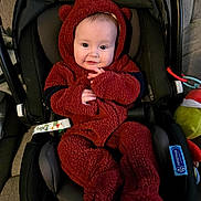 Paxton joined the competition — help win amazing prizes! baby, child, car_seat, onesie, red_clothing, plush, cute, indoor, toy, seatbelt, smiling, face, infant, childcare, cozy, portrait, person, warm_clothing, hand, head