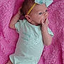 Charley is registered to the contest to win money with this photo: baby, infant, newborn, pink_blanket, onesie, headband, bow, hand, face, skin, clothing, cute, lying_down, soft_texture, portrait, small_person, baby_girl, sleepwear, fabric, baby_accessory