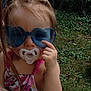 toddler, child, sunglasses, pacifier, outdoor, grass, summer, hair_ties, swimsuit, minnie_mouse, hand, pointing, cute, baby, person, playful, colorful, fun, portrait, sunny