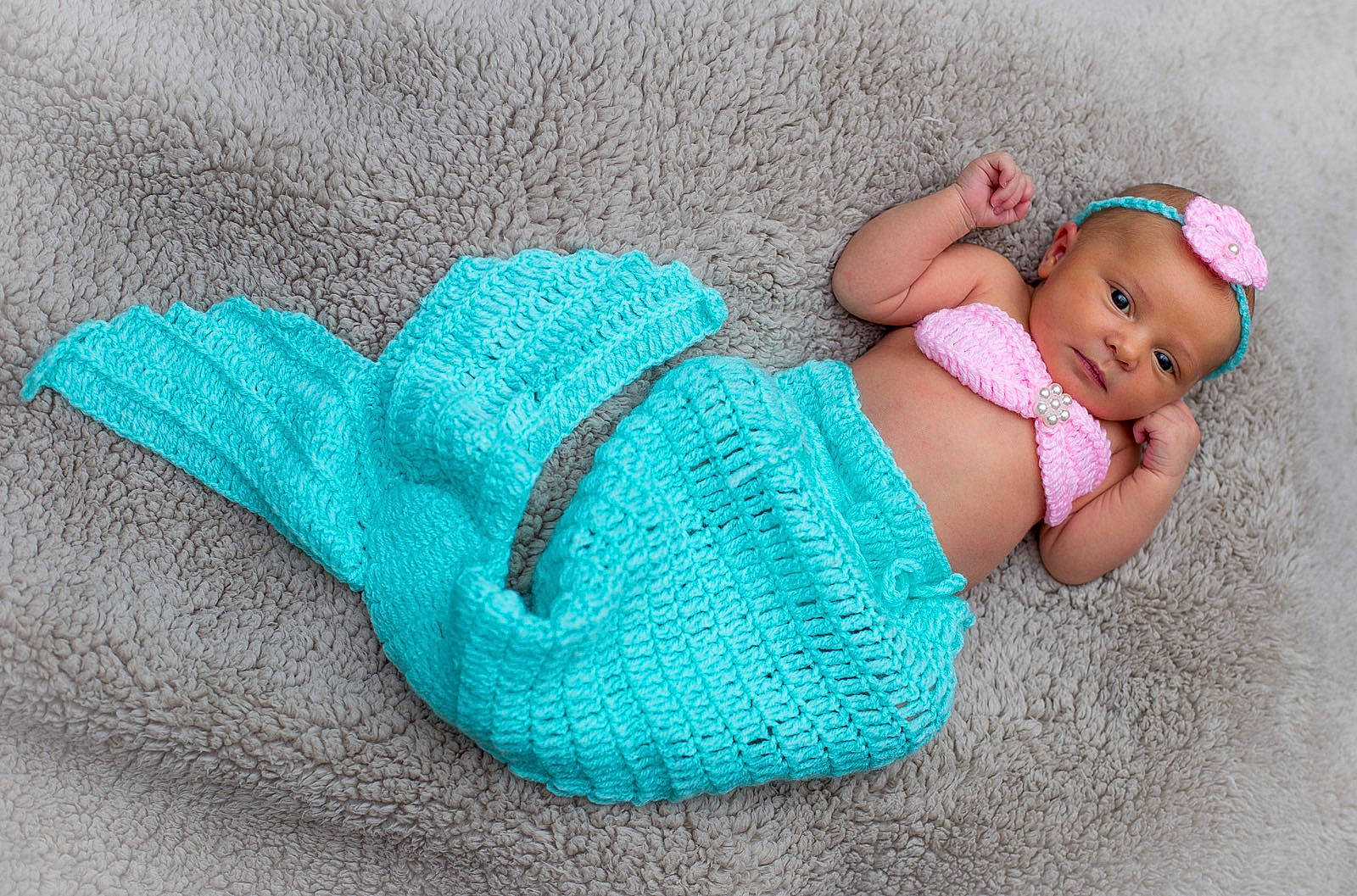 Jackie is registered to the contest to win money with this photo: aqua, baby, baby_products, baby_toddler_clothing, child, crochet, hair_accessory, headgear, knitting, pattern, person, product, toddler, turquoise, wool