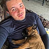 Beauty a rejoint le concours — aidez-le/la à gagner de superbes lots ! man, puppy, dog, couch, sleeping, indoor, relaxed, casual, brown_fur, black_shirt, facial_hair, tile_floor, clothing_rack, home, resting, cute, pet, young_adult, smile, cozy