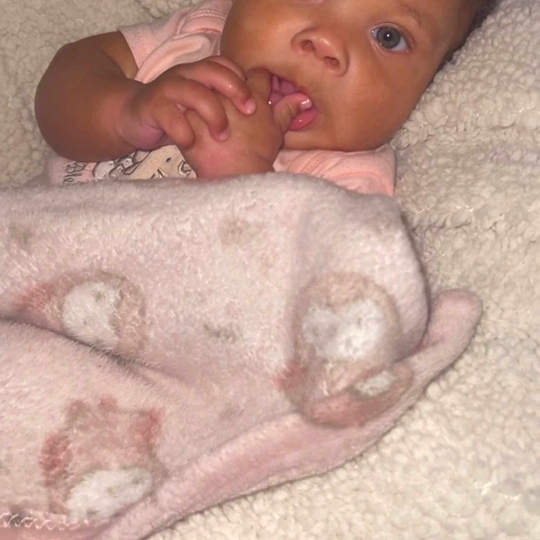 Jalaia joined the competition — help win amazing prizes! baby, infant, blanket, soft_texture, cute, face, hand, fingers, looking, curious, indoors, portrait, child, young, cozy, warm, person, skin, expression, sleepwear
