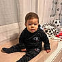 Mattéo Cristiano participe au concours pour gagner de l'argent avec cette photo : toddler, child, black_clothing, tracksuit, socks, indoor, curtains, cushion, soccer_ball, storage_basket, sports_theme, face, person, furniture, table, baby, portrait, sitting, casual, home