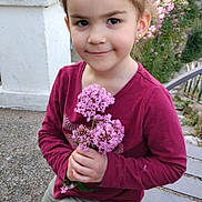Mélina a rejoint le concours — aidez-le/la à gagner de superbes lots ! bench, casual_clothing, child, concrete_wall, cute, daylight, earrings, flowers, girl, greenery, happy, long_sleeve_shirt, maroon_shirt, nature, outdoor, pants, pink_flowers, portrait, smile, young