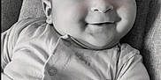 Kaïs participe au concours pour gagner de l'argent avec cette photo : baby, black_and_white, child, closeup, comfort, cushion, cute, expression, face, happy, indoors, infant, lying_down, monochrome, onesie, person, portrait, smiling, soft_texture, young